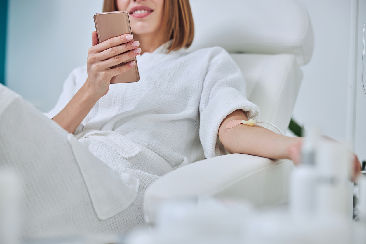 Woman smiles while getting IV Wellness treatment